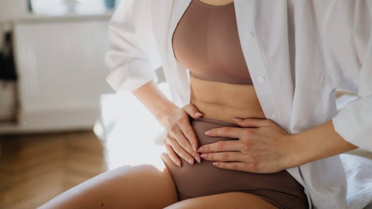 Mulher grávida a segurar a barriga, simbolizando maternidade e esperança.